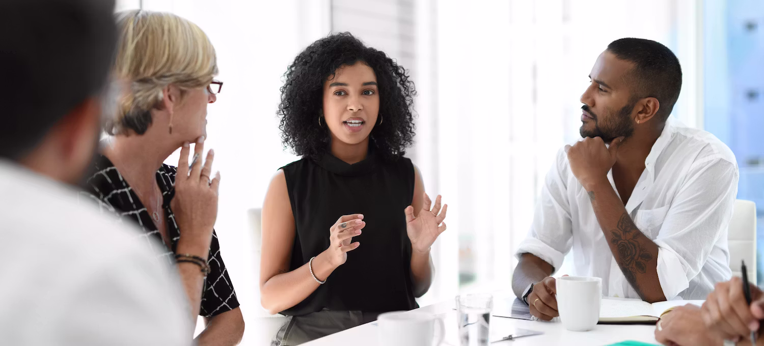Colleagues seated around a table during a structured workplace listening session
