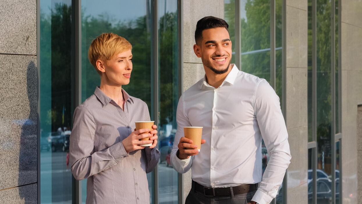 Colleagues taking a walking conversation outdoors during a workday break